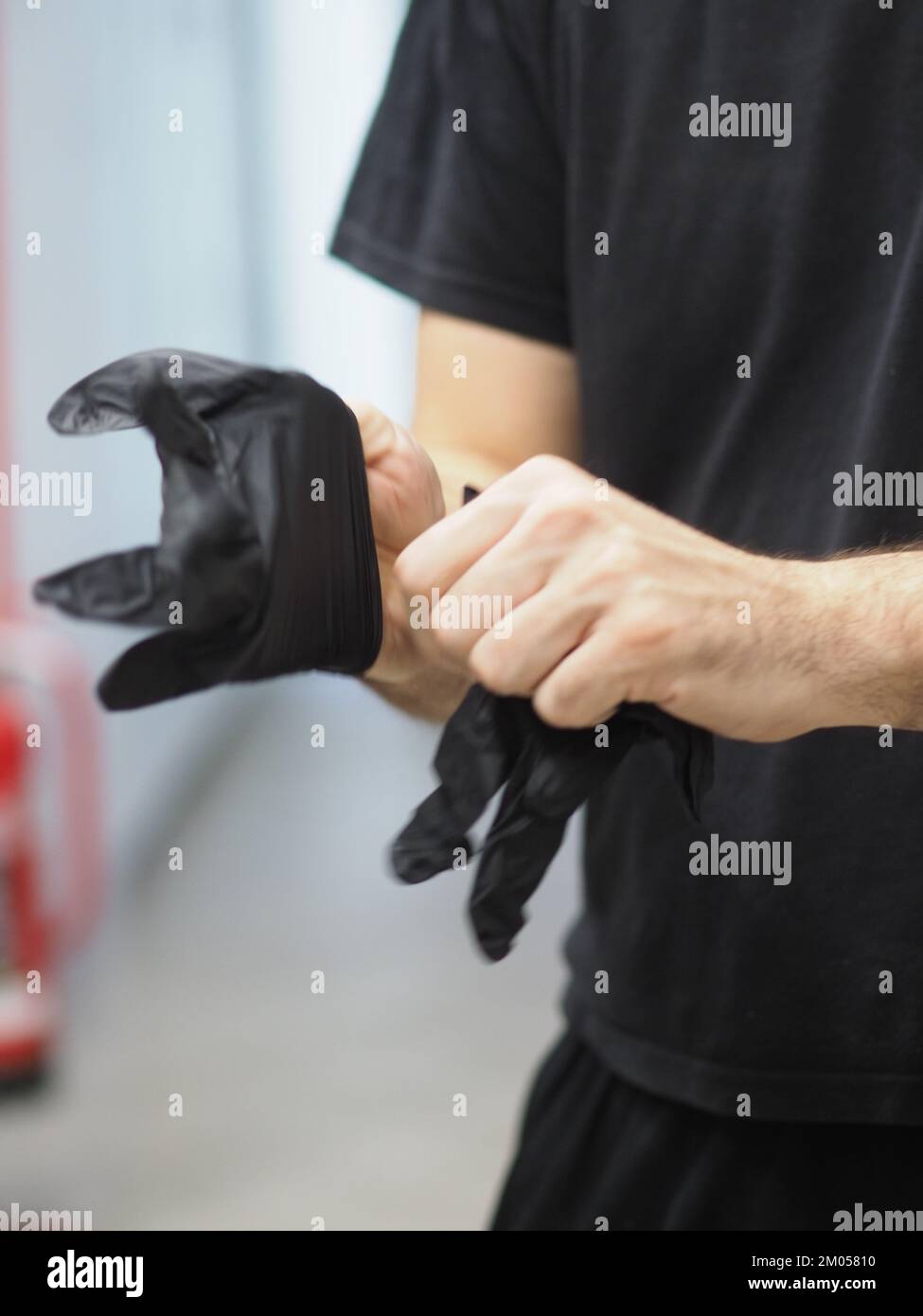 lo chef indossa guanti neri in una cucina professionale prima di cucinare filmati verticali Foto Stock