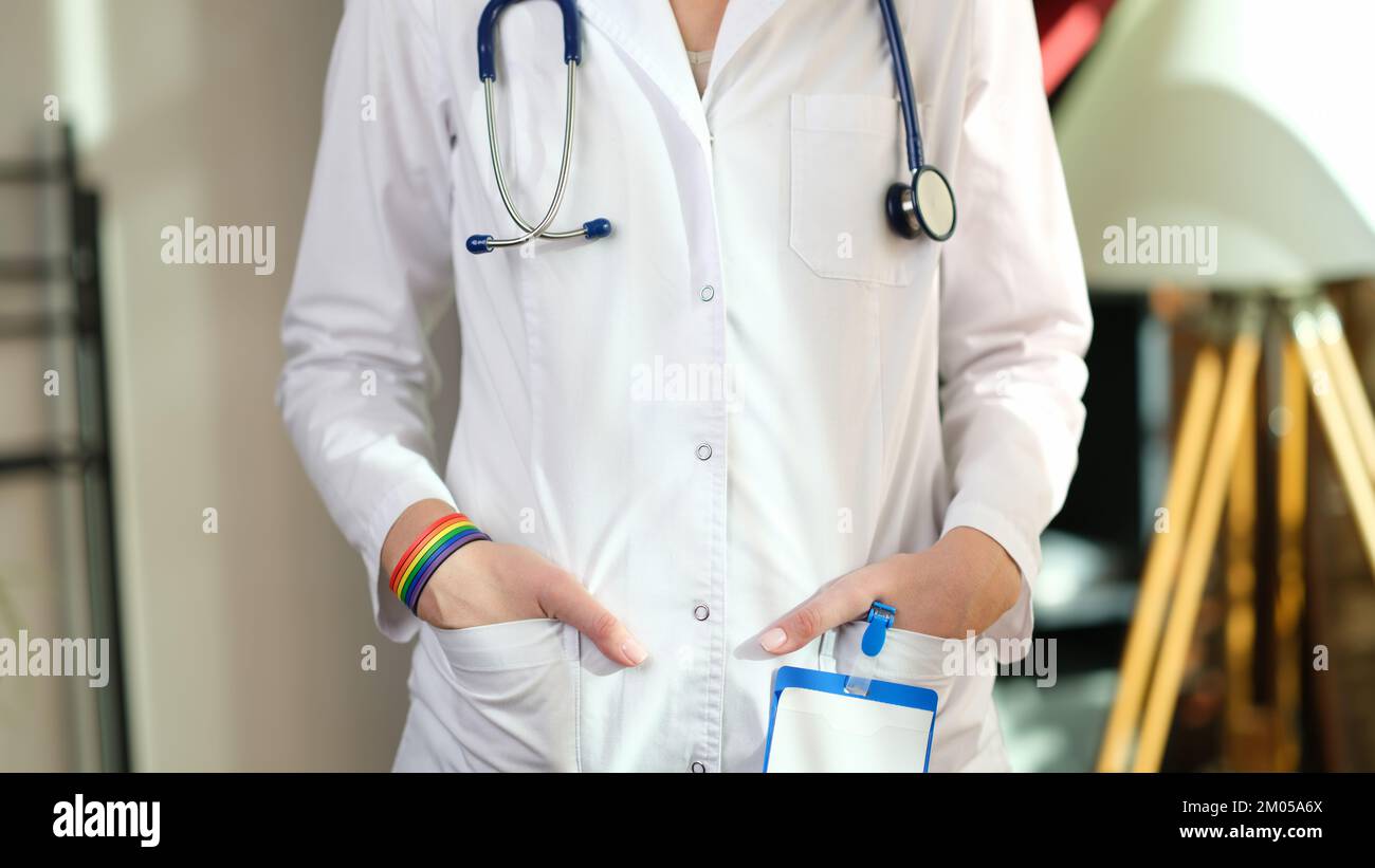 Medico donna con braccialetto lgbt in mano. Foto Stock