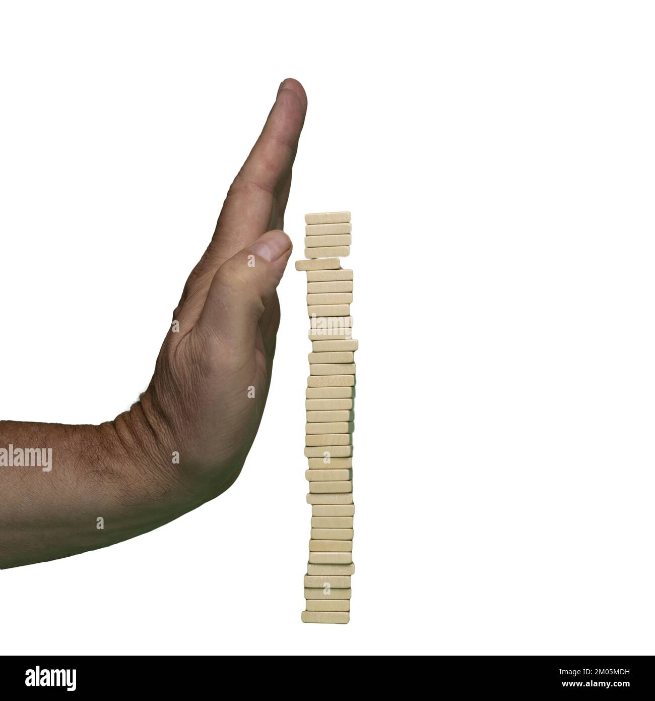 Una mano protegge una pila di tasselli di legno dalla caduta. Il concetto di protezione dei sistemi instabili Foto Stock