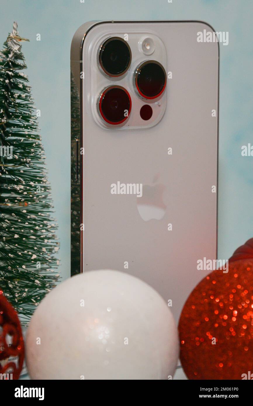 Riga/Lettonia - 4 dicembre 2022: Nuovo telefono moderno iPhone 14 pro tra le scintillanti decorazioni natalizie su sfondo nero. Regalo di Natale conce Foto Stock