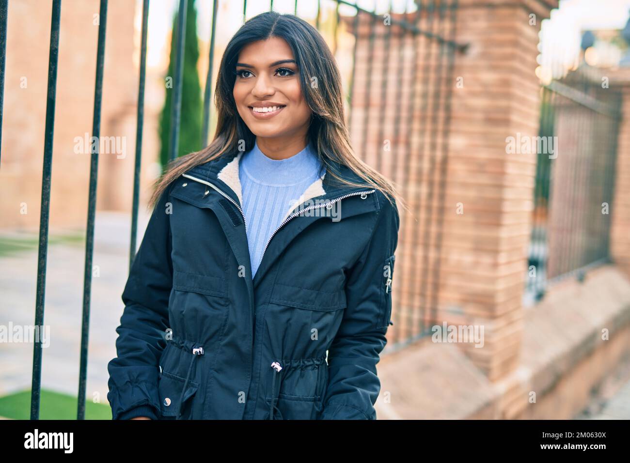 Bella donna ispanica sorridente confidente in città Foto Stock