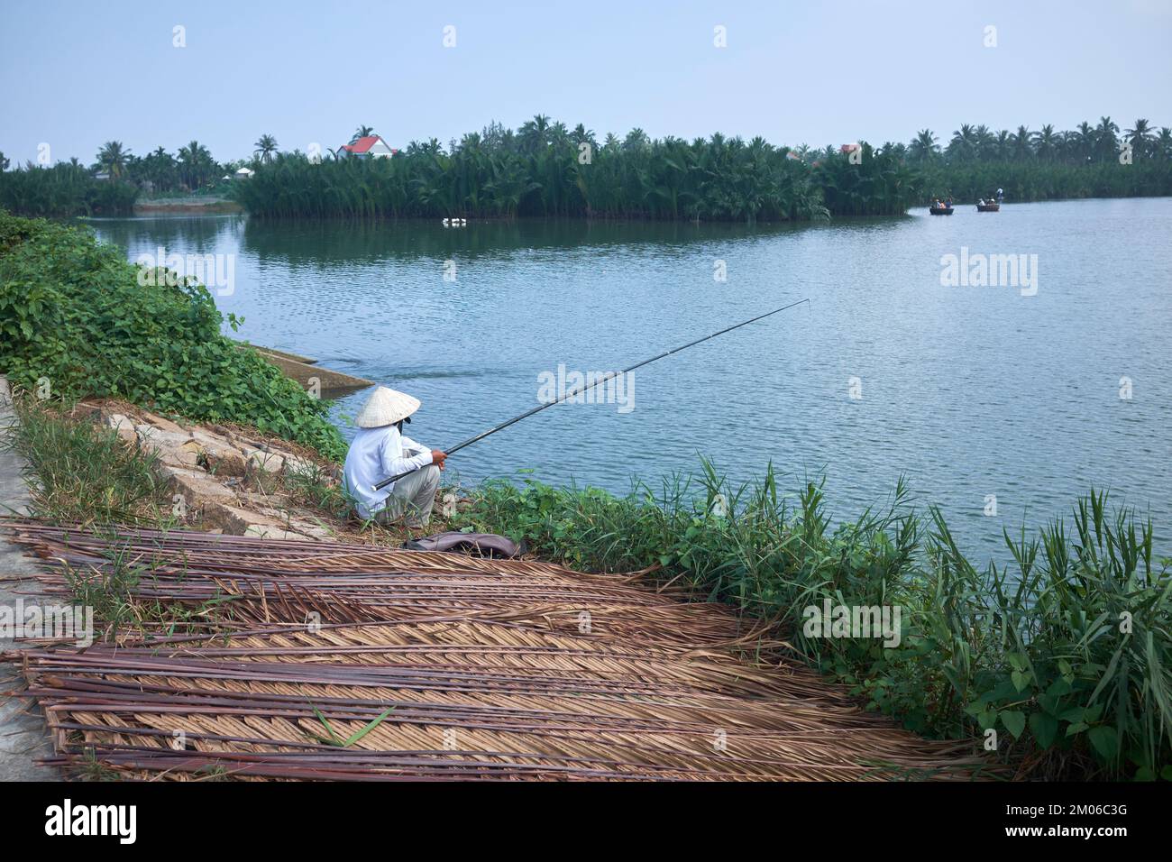 Pescatore in coolie cappello sulle zone umide a Hoi An Vietnam Foto Stock