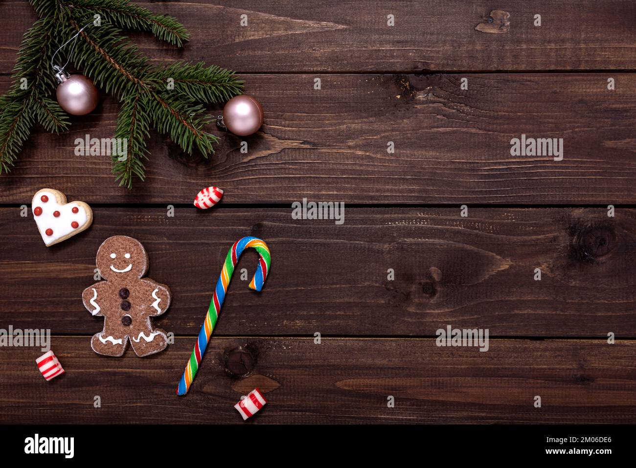 Composizione natalizia con biscotti di pan di zenzero, rami di abete e decorazioni natalizie su tavolo di legno con spazio copia per il testo. Foto Stock
