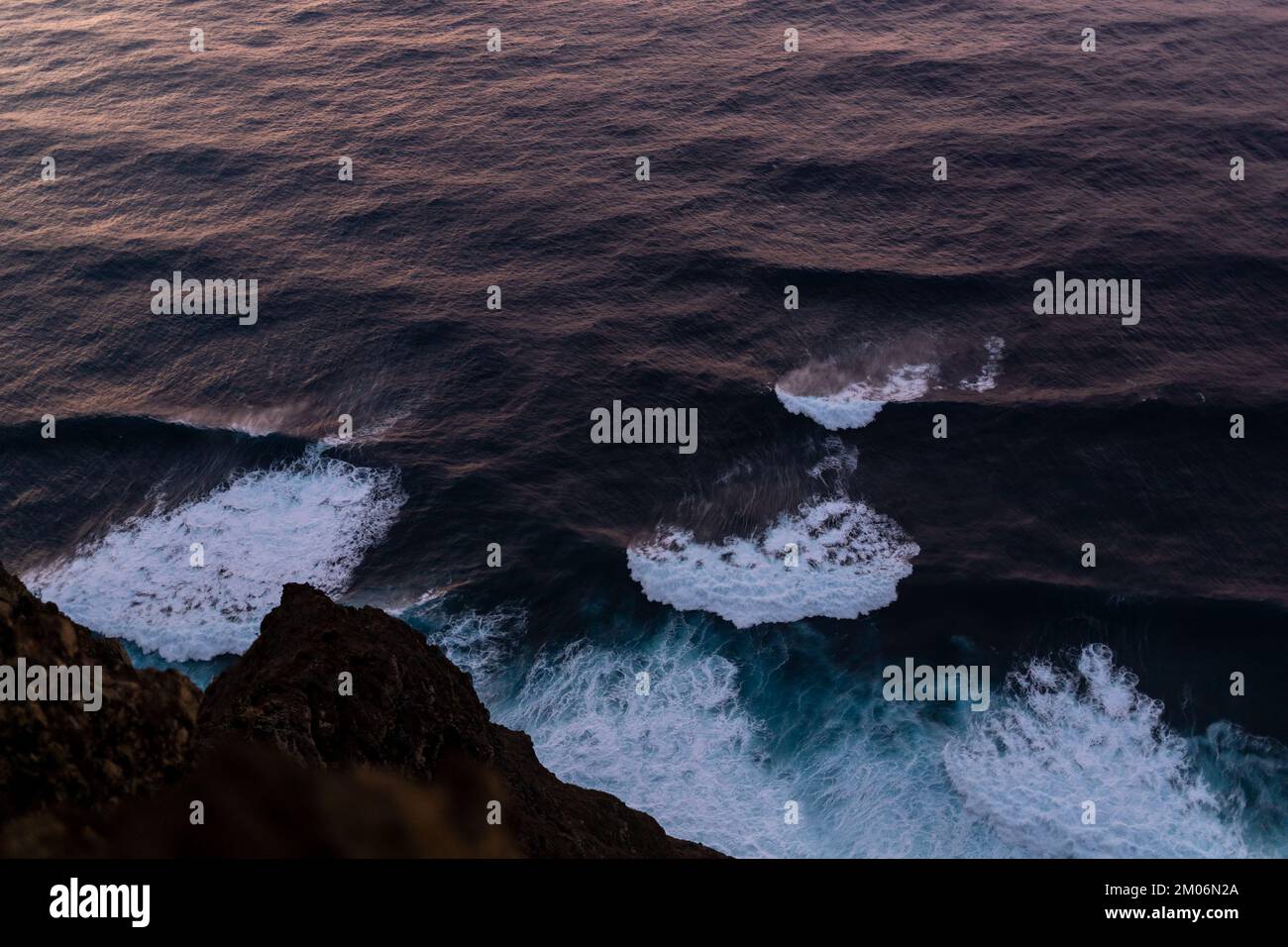 onde da surf sull'oceano con vista del tramonto dall'alto Foto Stock