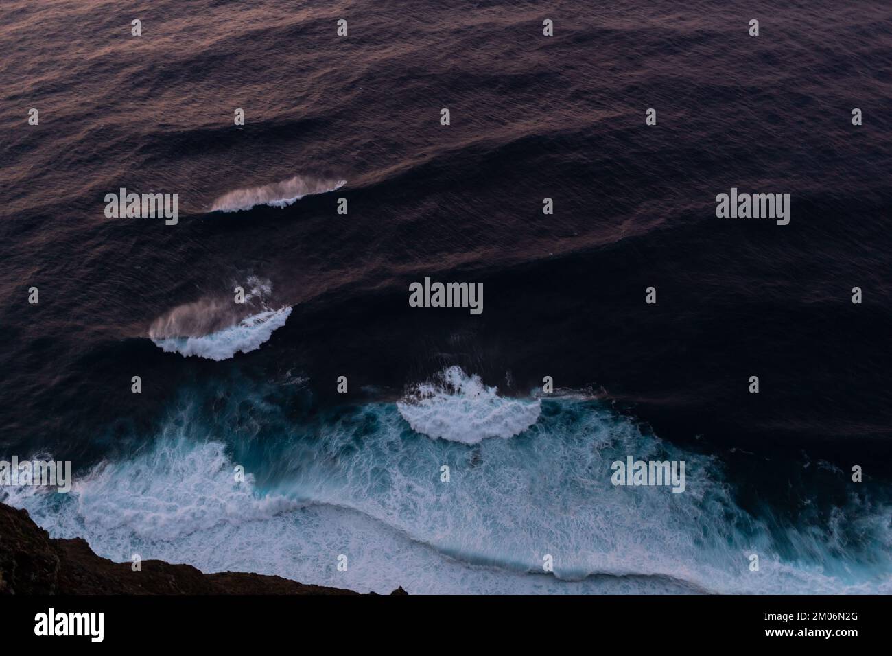 onde da surf sull'oceano con vista del tramonto dall'alto Foto Stock