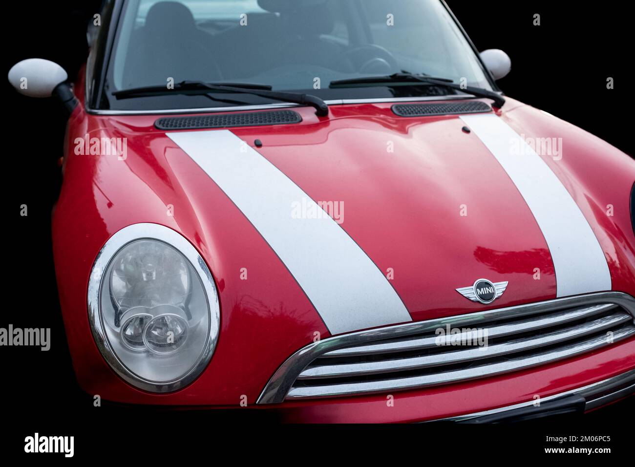 Red Color Car con White Stripes Mini Cooper parcheggiato su strada isolato su sfondo nero. Vista frontale dettagli di MINI Cooper-Novembre 11,2022-Vancouv Foto Stock