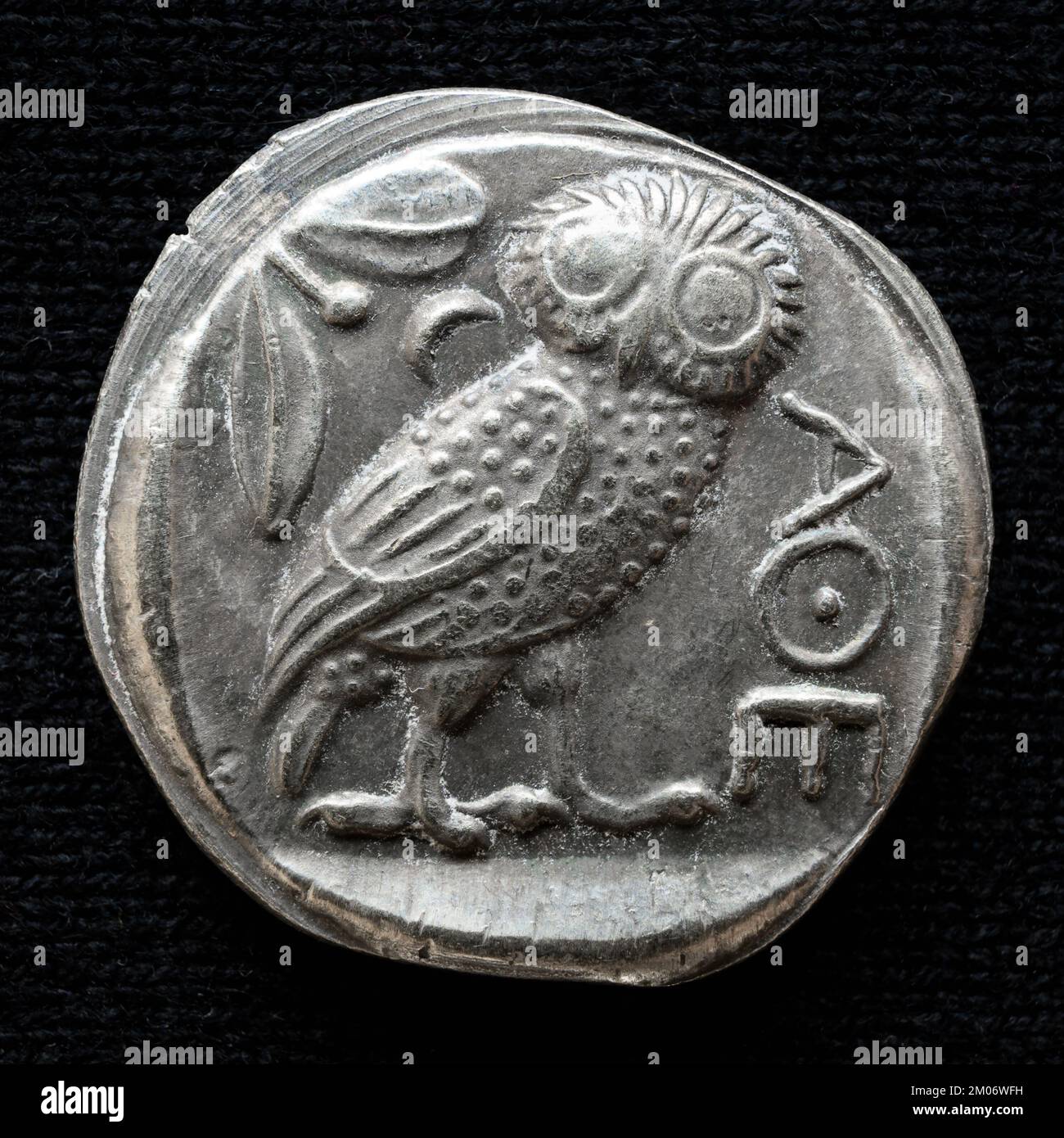 Antica moneta greca con civetta e iscrizione Atene. Vecchi soldi rari, tetradrachm argento isolato su sfondo scuro, macro. Concetto di Grecia, valore Foto Stock