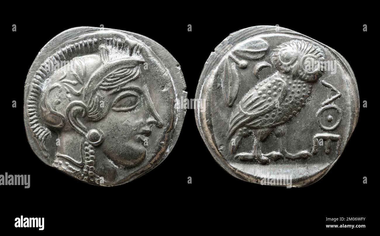 Antica moneta greca che mostra la dea Atena e gufo. Vecchio denaro raro di Atene, tetradrachm argento isolato su sfondo nero, macro. Tema della Grecia, Foto Stock