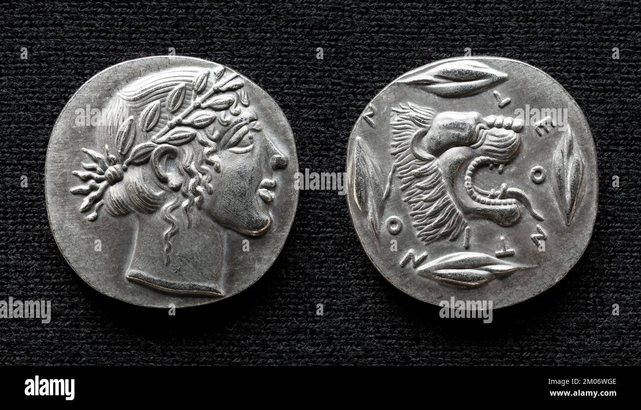 Antica moneta greca raffigurante dio Apollo e leone ruggente, vecchi soldi rari di Leontini, Sicilia. Tetradrachm argento isolato su scuro, macro. Tema di GRE Foto Stock