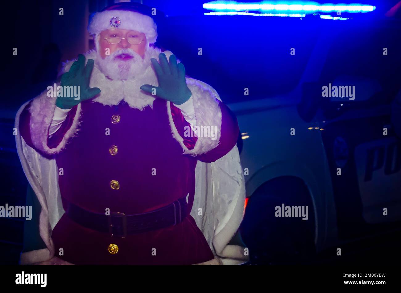 Babbo Natale si trova di fronte a un'auto della polizia durante l'illuminazione dell'albero di Natale della città al Mardi Gras Park, 18 novembre 2022, a Mobile, Alabama. Foto Stock