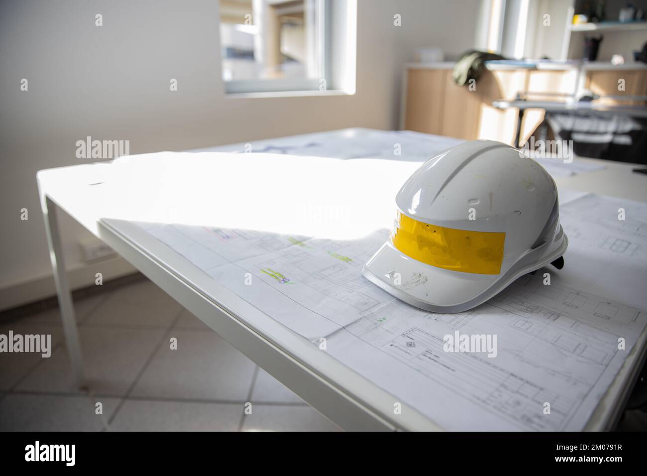 Tavolo con disegno tecnico e casco di protezione, concetto di carpenteria industriale Foto Stock