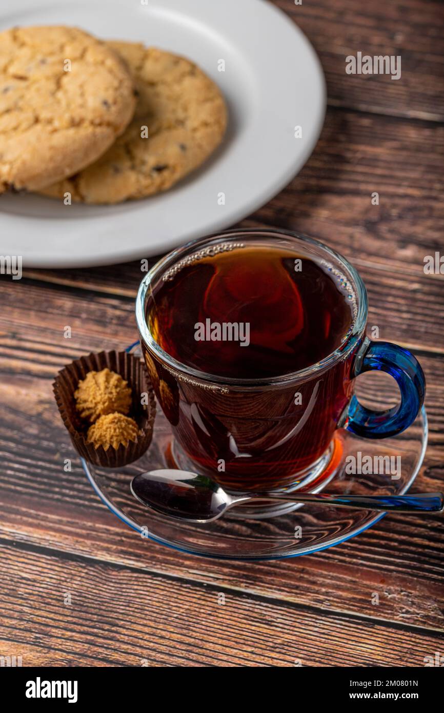 Tè turco nero in tazza di vetro con shortbread su tavolo di legno Foto Stock