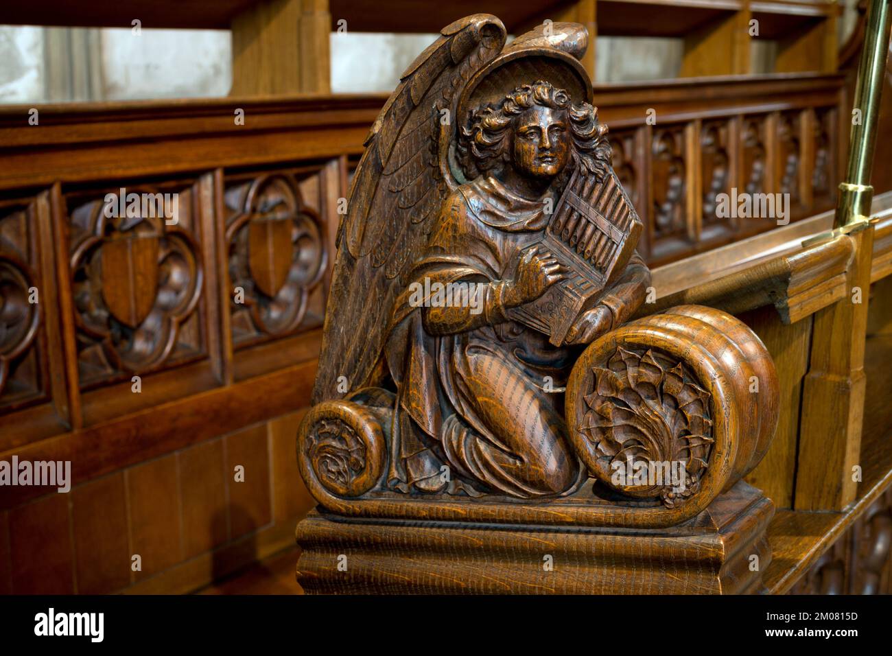 Un angelo musicista intagliato nelle bancarelle del coro, St. Mary`s Church, Warwick, Warwickshire, Regno Unito Foto Stock