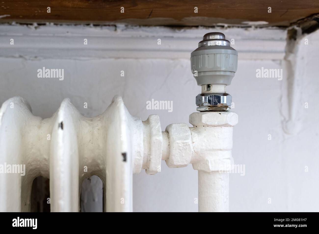 Vecchio radiatore di riscaldamento domestico in ghisa nel soggiorno Foto Stock