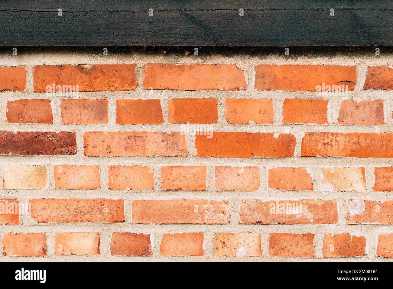 Parete rustica in mattoni con vecchio travetto in legno come sfondo. Dettaglio da Halmstad, Svezia. Foto Stock
