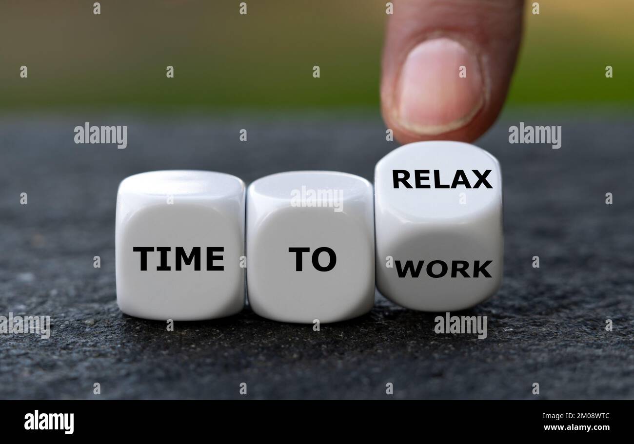 La mano gira i dadi e cambia l'espressione "tempo di lavorare" in "tempo di rilassarsi". Foto Stock