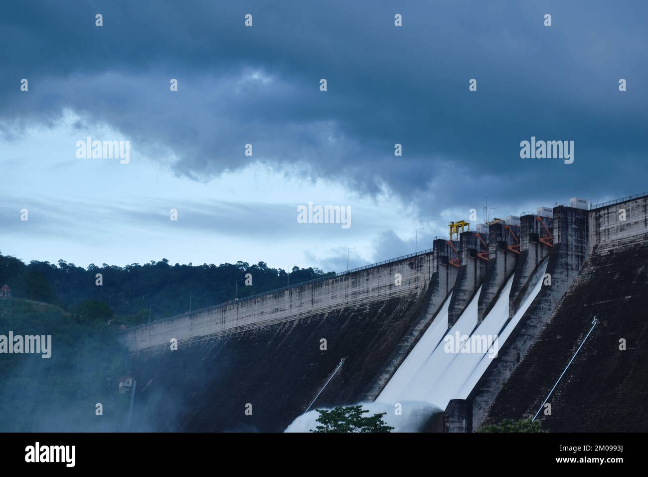 Spruzzi d'acqua dal cancello Khun Dan Prakarn Chon enorme diga di cemento di notte in Thailandia Foto Stock