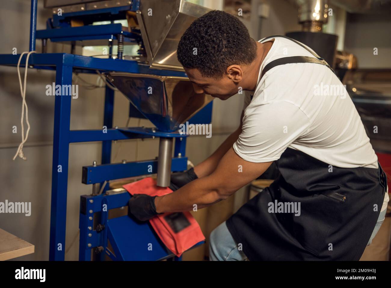 Operatore che sigilla il sacchetto del caffè con un sigillatore a caldo Foto Stock