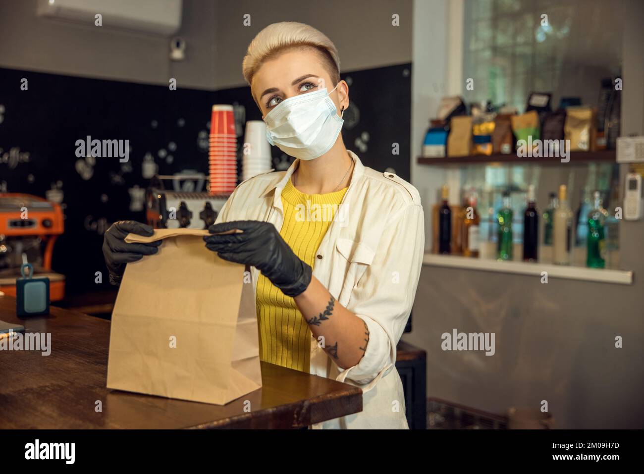 Barista giovane e sognante che gestisce un ordine cliente Foto Stock