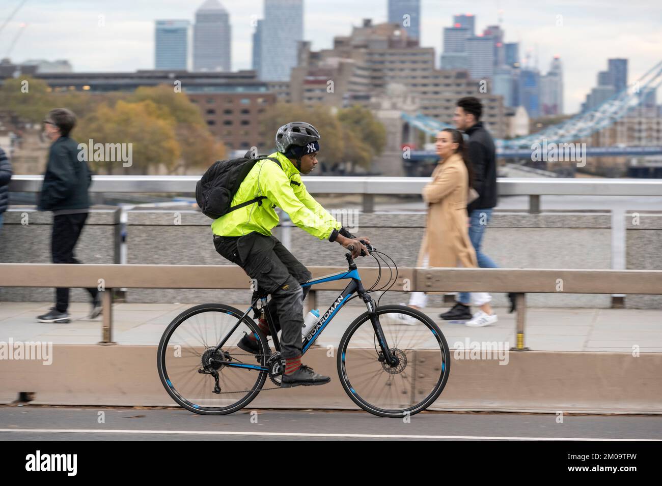 Un uomo che si collega in bicicletta durante l'ora di punta attraverso il London Bridge, Londra, Regno Unito. 18 Nov 2022 Foto Stock