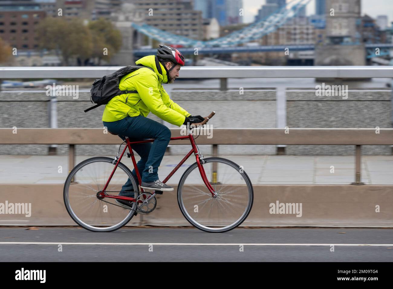 Un uomo che si collega in bicicletta durante l'ora di punta attraverso il London Bridge, Londra, Regno Unito. 18 Nov 2022 Foto Stock
