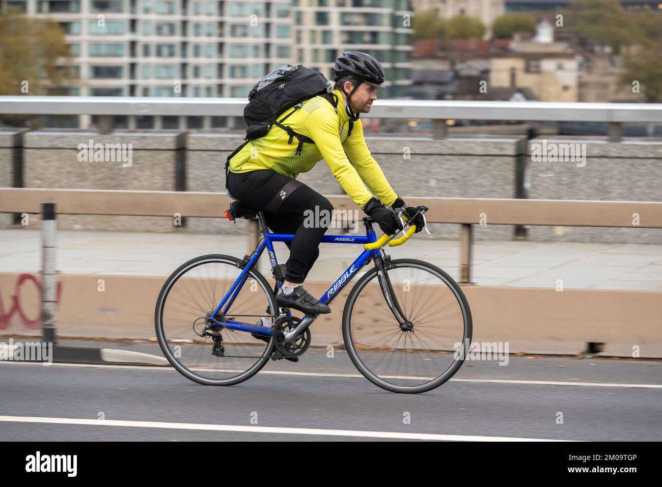 Un uomo che si collega in bicicletta durante l'ora di punta attraverso il London Bridge, Londra, Regno Unito. 18 Nov 2022 Foto Stock