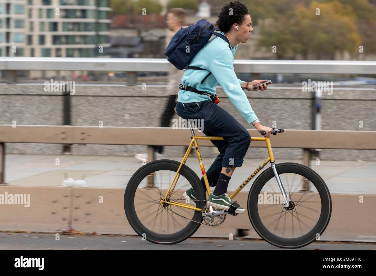 Un uomo che si collega in bicicletta durante l'ora di punta attraverso il London Bridge, Londra, Regno Unito. 18 Nov 2022 Foto Stock