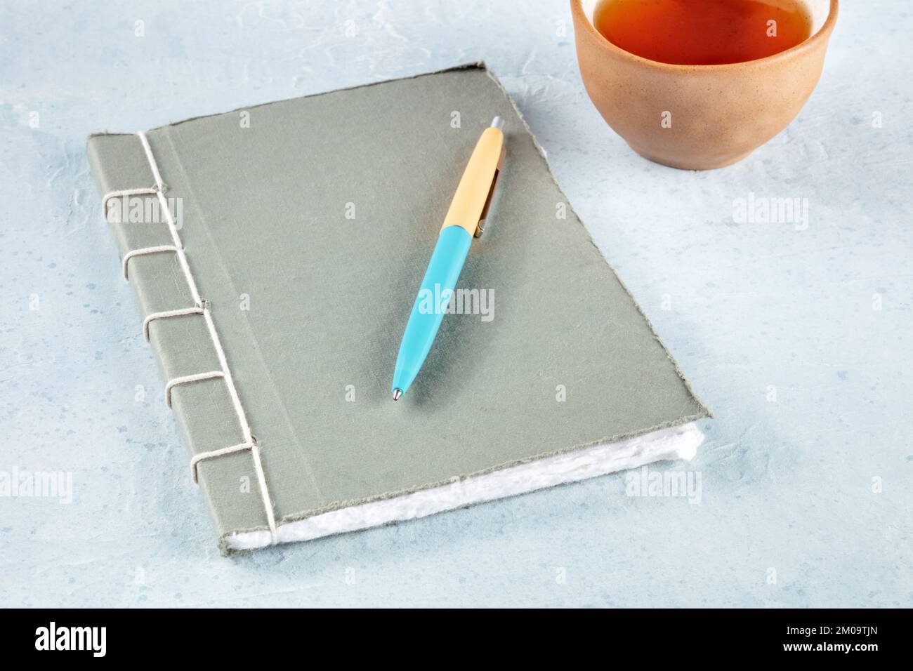 Diario. Un giornale cucito a mano con una penna e una tazza di tè, stile minimalista Foto Stock