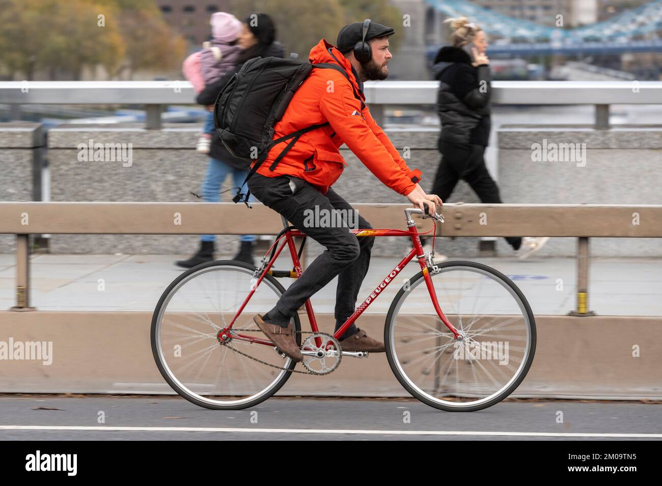 Un uomo che si collega in bicicletta durante l'ora di punta attraverso il London Bridge, Londra, Regno Unito. 18 Nov 2022 Foto Stock