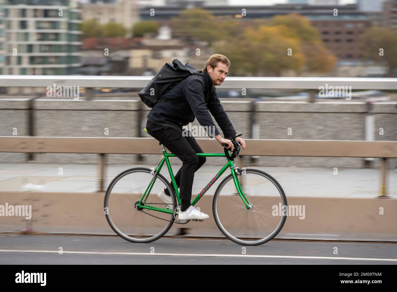 Un uomo che si collega in bicicletta durante l'ora di punta attraverso il London Bridge, Londra, Regno Unito. 18 Nov 2022 Foto Stock