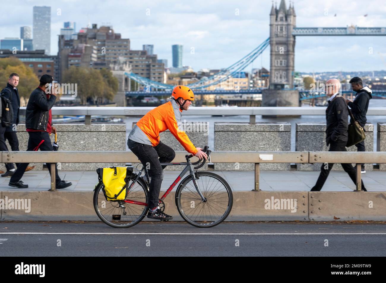 Un uomo che si collega in bicicletta durante l'ora di punta attraverso il London Bridge, Londra, Regno Unito. 17 Nov 2022 Foto Stock
