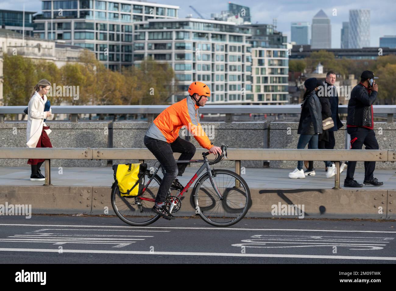 Un uomo che si collega in bicicletta durante l'ora di punta attraverso il London Bridge, Londra, Regno Unito. 17 Nov 2022 Foto Stock