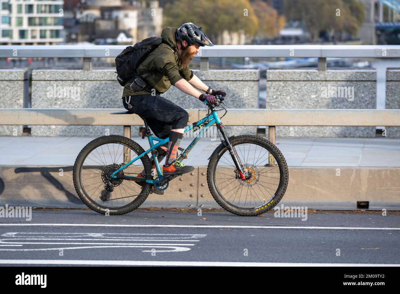 Un uomo che si collega in bicicletta durante l'ora di punta attraverso il London Bridge, Londra, Regno Unito. 17 Nov 2022 Foto Stock