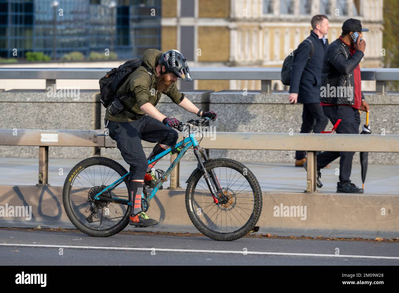 Un uomo che si collega in bicicletta durante l'ora di punta attraverso il London Bridge, Londra, Regno Unito. 17 Nov 2022 Foto Stock