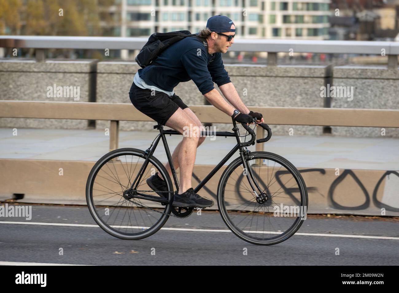 Un uomo che si collega in bicicletta durante l'ora di punta attraverso il London Bridge, Londra, Regno Unito. 17 Nov 2022 Foto Stock