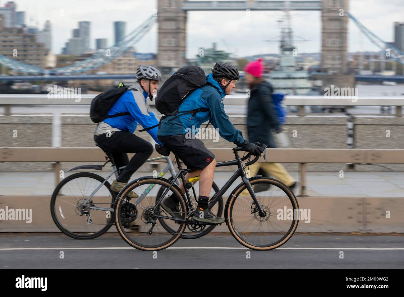 Un uomo che si collega in bicicletta durante l'ora di punta attraverso il London Bridge, Londra, Regno Unito. 17 Nov 2022 Foto Stock