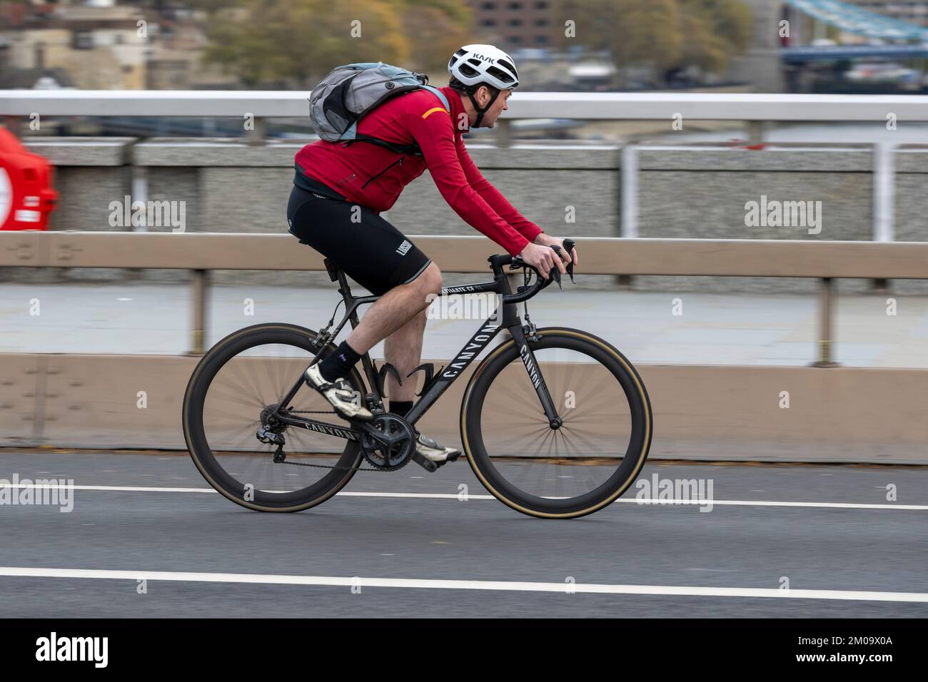 Un uomo che si collega in bicicletta durante l'ora di punta attraverso il London Bridge, Londra, Regno Unito. 17 Nov 2022 Foto Stock