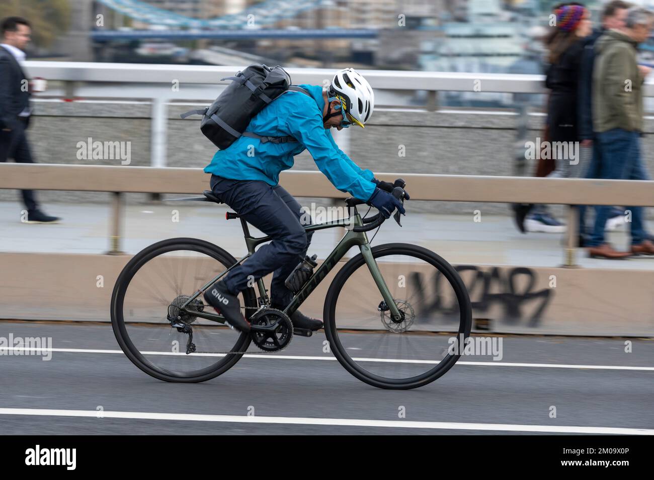 Un uomo che si collega in bicicletta durante l'ora di punta attraverso il London Bridge, Londra, Regno Unito. 17 Nov 2022 Foto Stock