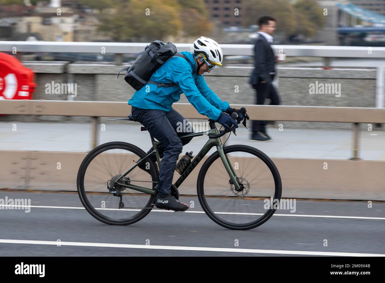 Un uomo che si collega in bicicletta durante l'ora di punta attraverso il London Bridge, Londra, Regno Unito. 17 Nov 2022 Foto Stock