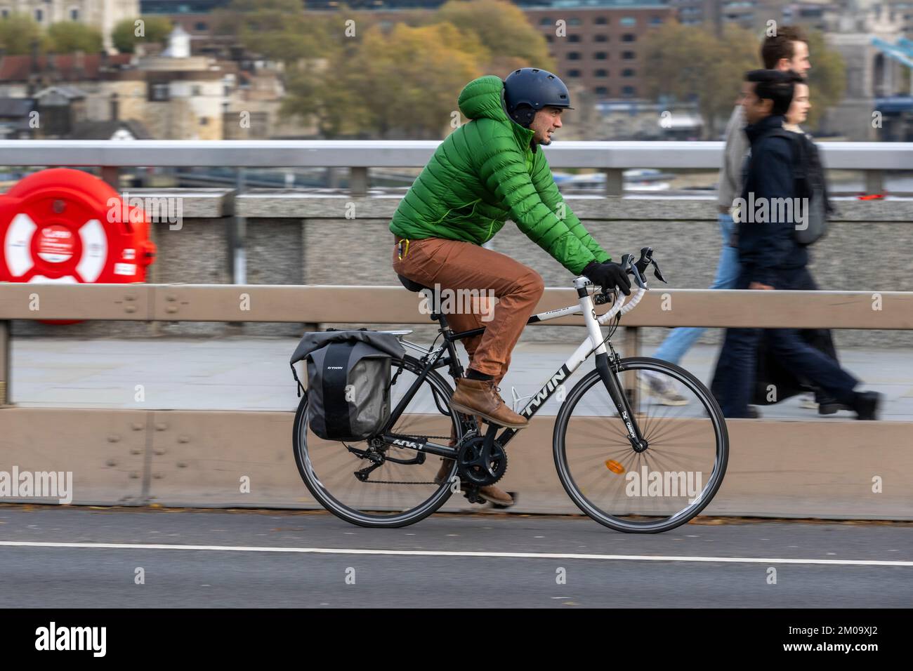 Un uomo che si collega in bicicletta durante l'ora di punta attraverso il London Bridge, Londra, Regno Unito. 17 Nov 2022 Foto Stock