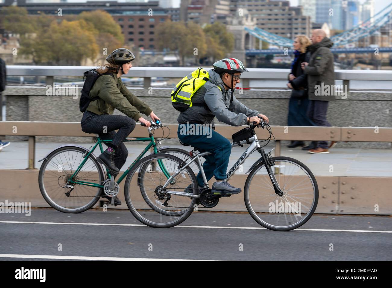 Un uomo che si collega in bicicletta durante l'ora di punta attraverso il London Bridge, Londra, Regno Unito. 17 Nov 2022 Foto Stock