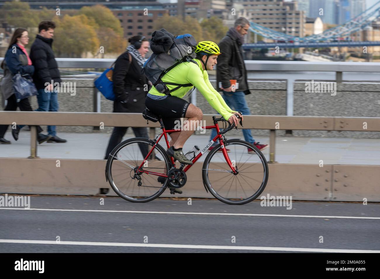 Un uomo che si collega in bicicletta durante l'ora di punta attraverso il London Bridge, Londra, Regno Unito. 17 Nov 2022 Foto Stock