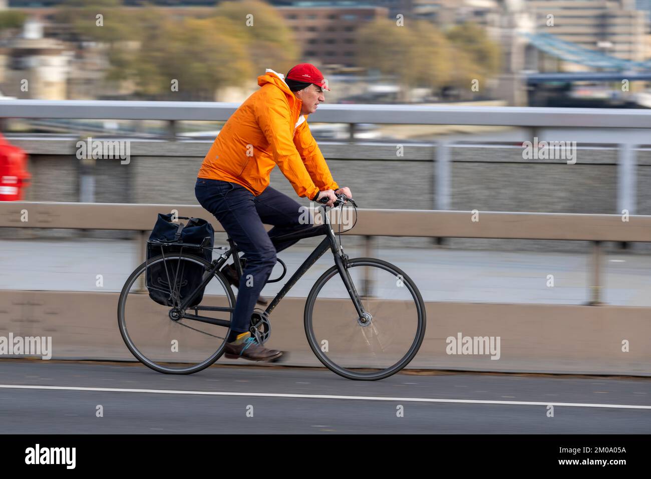 Un uomo che si collega in bicicletta durante l'ora di punta attraverso il London Bridge, Londra, Regno Unito. 17 Nov 2022 Foto Stock