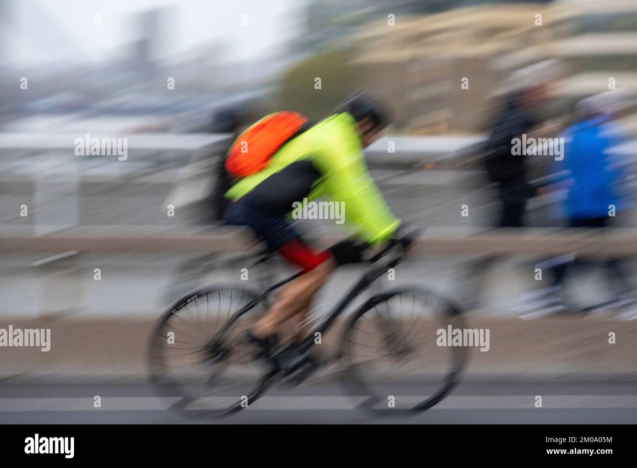 Un uomo che si collega in bicicletta durante l'ora di punta attraverso il London Bridge, Londra, Regno Unito. 16 Nov 2022 Foto Stock