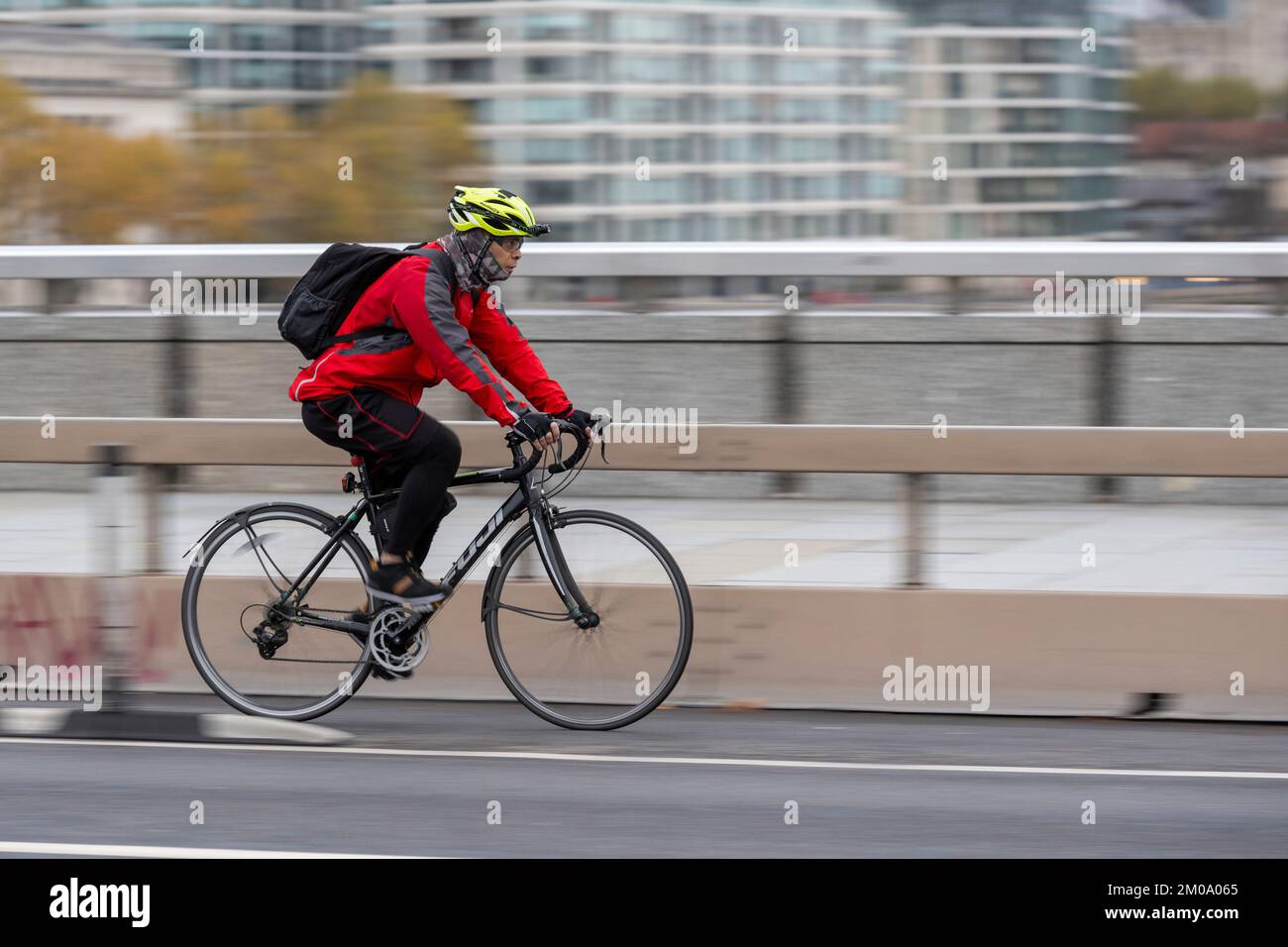 Un uomo che si collega in bicicletta durante l'ora di punta attraverso il London Bridge, Londra, Regno Unito. 16 Nov 2022 Foto Stock