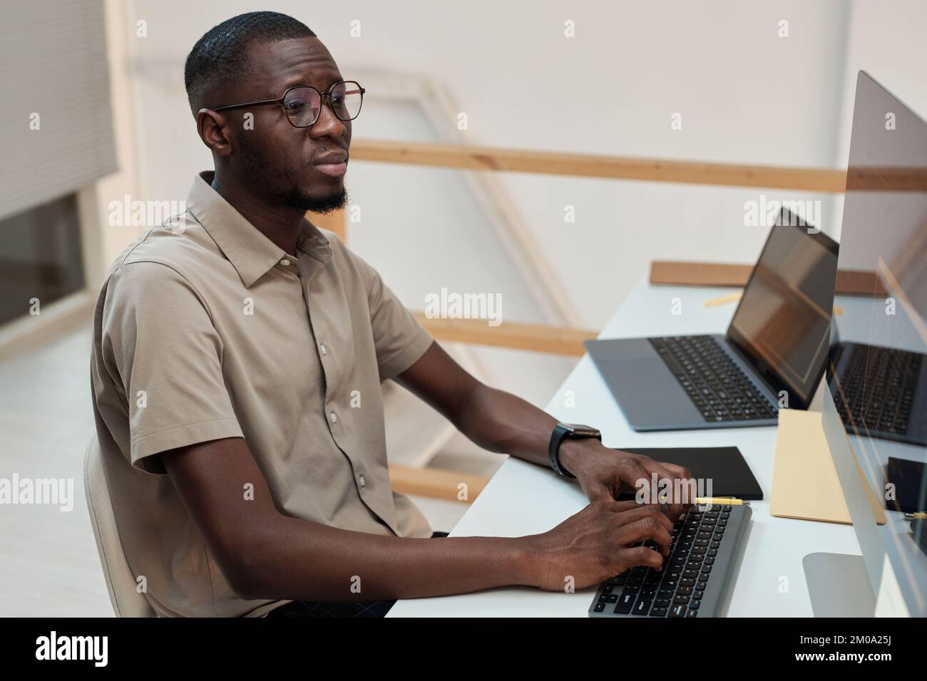 Vista laterale del programmatore Serious Black che sviluppa aggiornamenti software Foto Stock