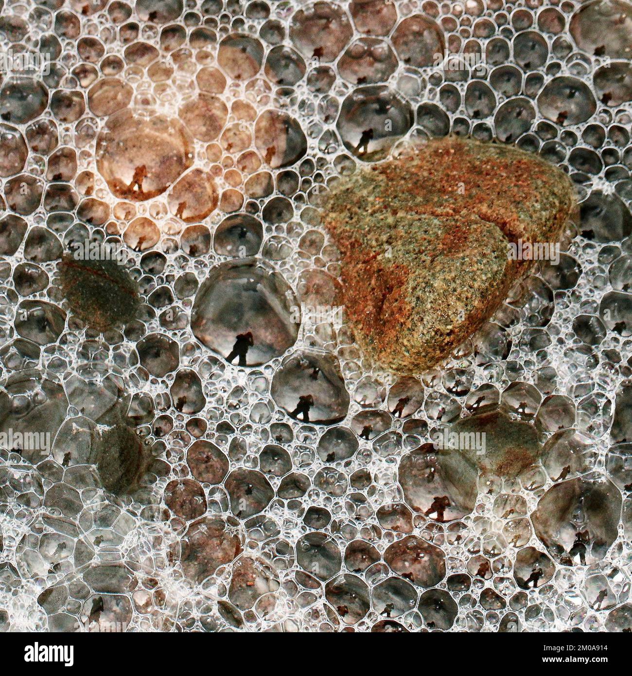 Fotografia a colori delle pietre costiere sulla spiaggia levigata e arrotondata dai passaggi del tempo e della marea, contenente pietre ciottoli ciottoli ciottoli Foto Stock