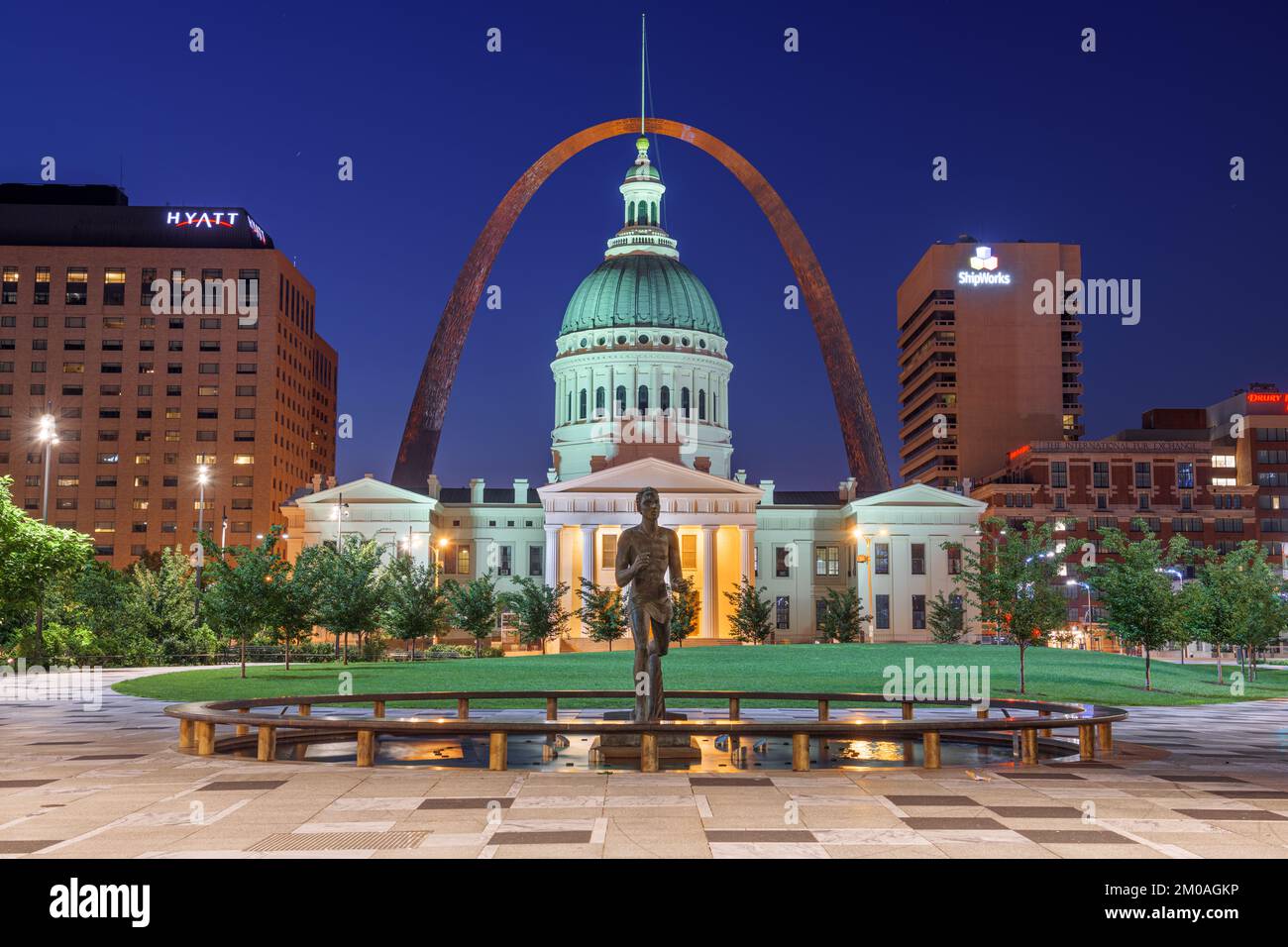 ST. LOUIS, MISSOURI, USA - 23 agosto 2018: Vista dal Kiener Plaza Park con la Statua del Runner Olimpico, il vecchio tribunale e il Gateway Arch a Twilig Foto Stock