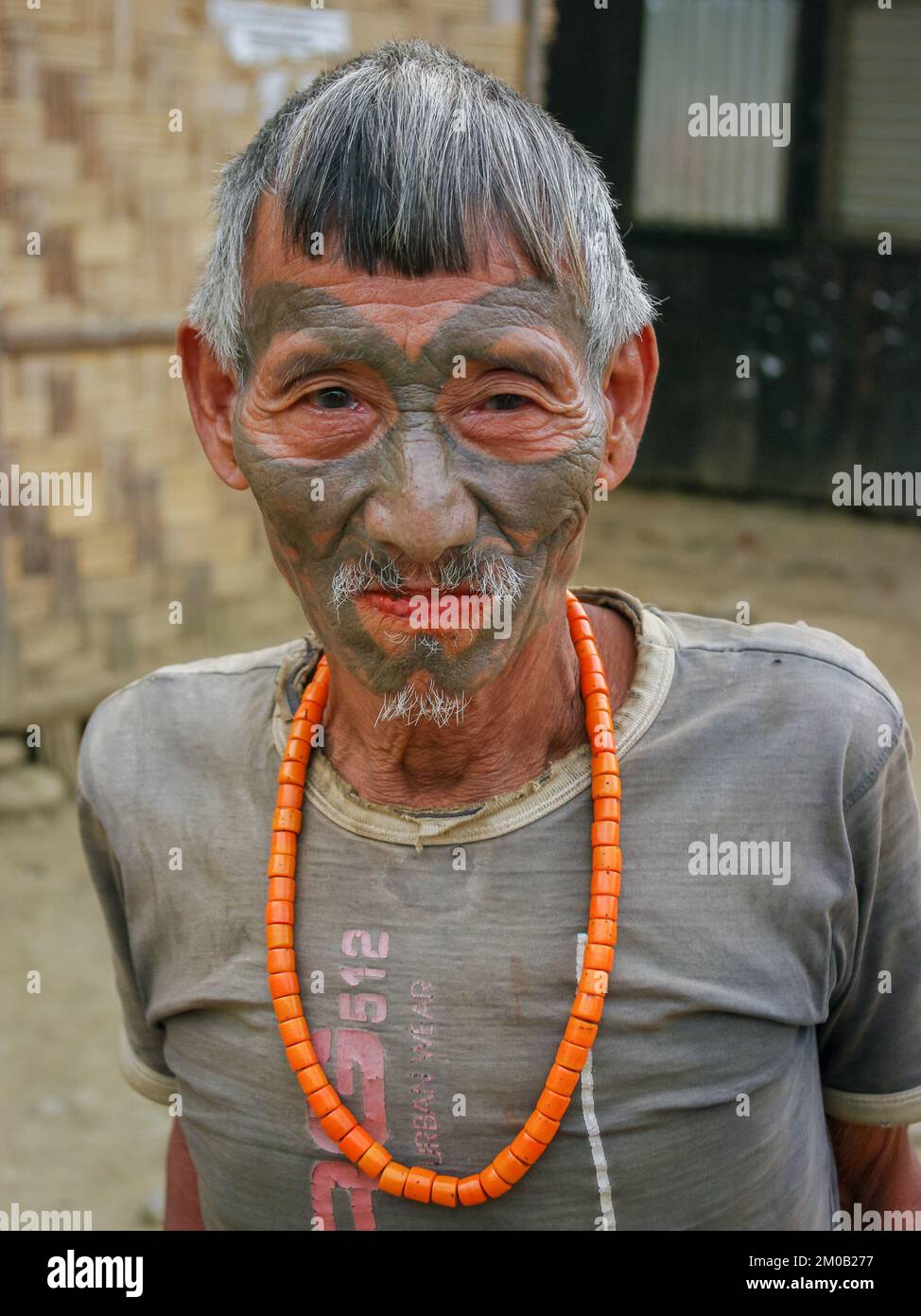 Mon District, Nagaland, India - 03 09 2014 : ritratto della vecchia tribù Naga Konyak cacciatore guerriero testa con tatuaggio facciale tradizionale e collana corallo Foto Stock