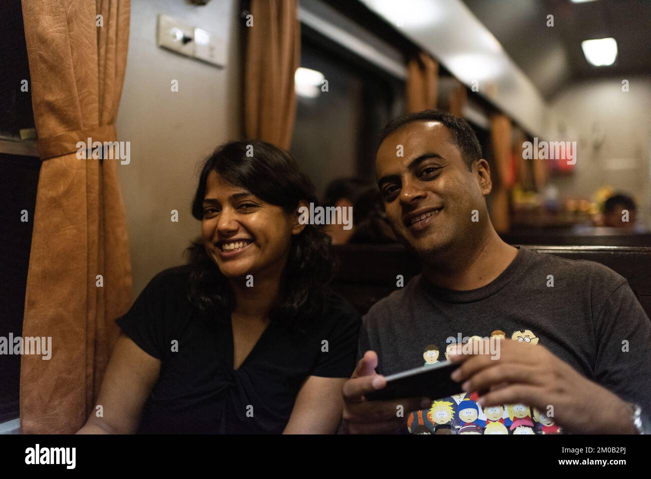 Hanoi, Vietnam; 16 settembre 2018: Sorriso di coppia mediorientale guardando il fotografo in viaggio in treno Foto Stock